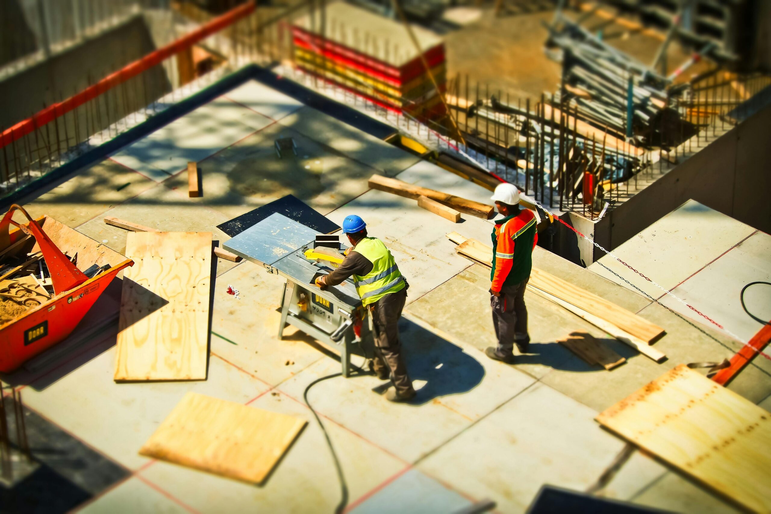 Serviços Construction workers engaging in tasks at an outdoor building site with safety hats and equipment.