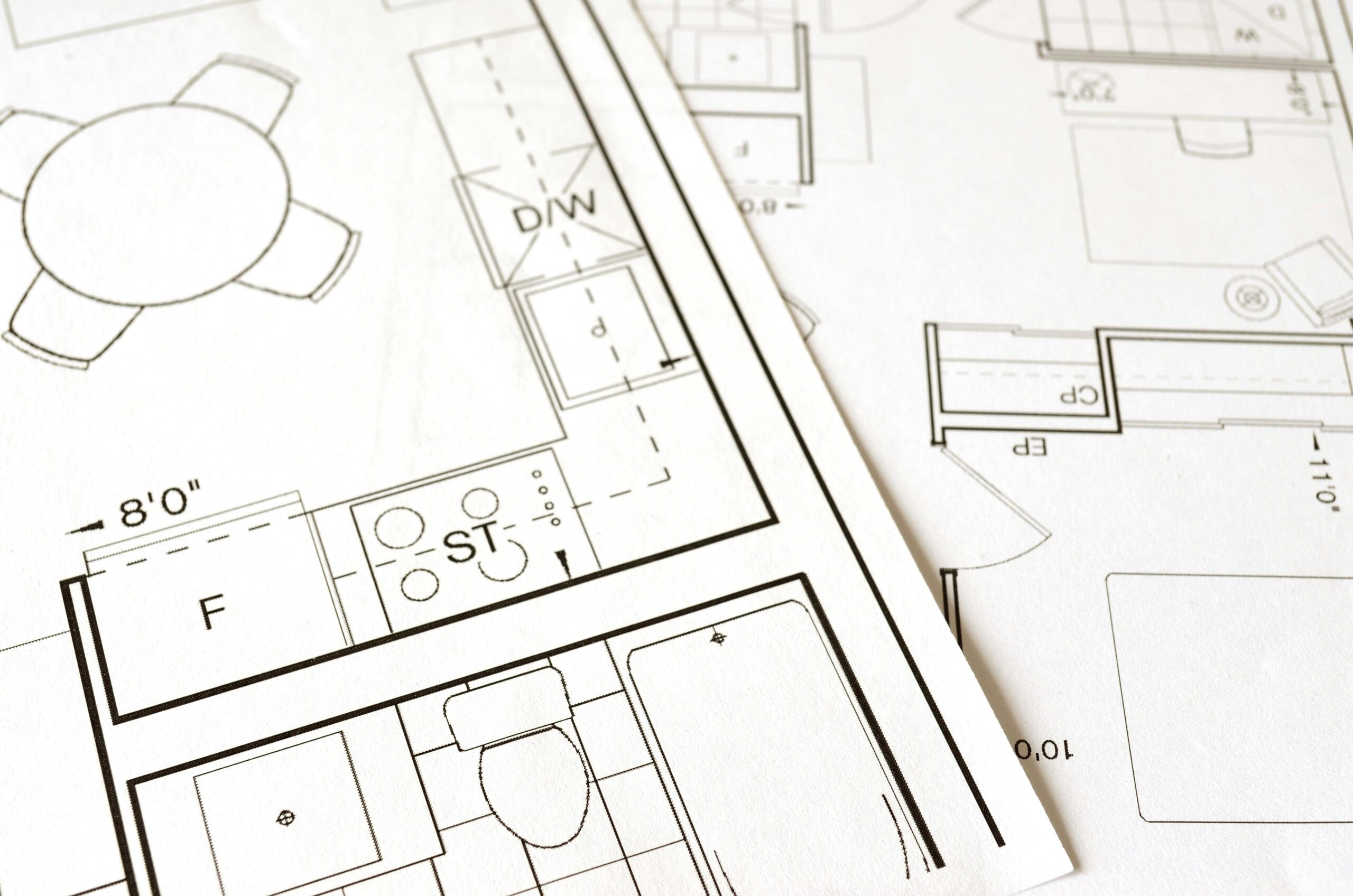 Serviços Close-up view of an architectural floor plan on paper showcasing detailed room layouts and measurements.